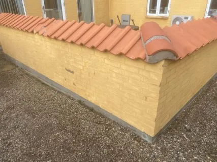 Gul mur med tegltag efter rensning